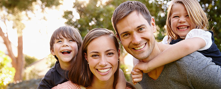 family smiling outside